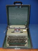An olive green Olympia typewriter, in black case, a/f.