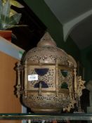 A hanging middle eastern Islamic brass Lantern with coloured glass panels, 14" tall.