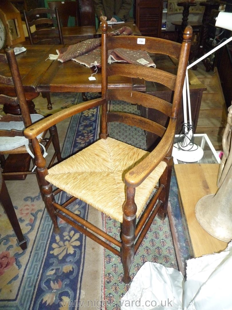 A good Oak ladder back open armed Elbow Chair having turned legs,