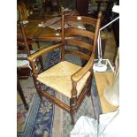 A good Oak ladder back open armed Elbow Chair having turned legs,