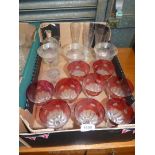A quantity of glasses including nine cranberry and clear goblets, five bud vases with square bases,