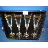 Four Biba Champagne flutes with gold detail, boxed.