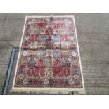 An ivory Kashmir silk rug having ivory panel and individual square design in blue, red,