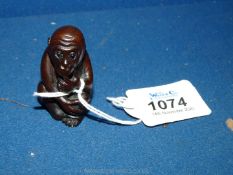 A well carved hardwood Netsuke in the form of a Monkey seated with pensive expression, 2 1/2'' tall.