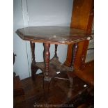 An Edwardian Mahogany octagonal Occasional Table standing on turned legs with a lower shelf and a