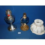 Two indoor oil lamps, one with white shade.