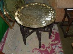 A circular engraved brass Benares table top with original carved wooden base c. 1900.