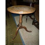 A mid Oak circular occasional table standing on turned pillar with three splay feet,