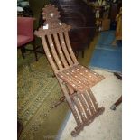 An unusual slatted Eastern hardwood folding chair decorated with blind fret-work/carved scroll-work