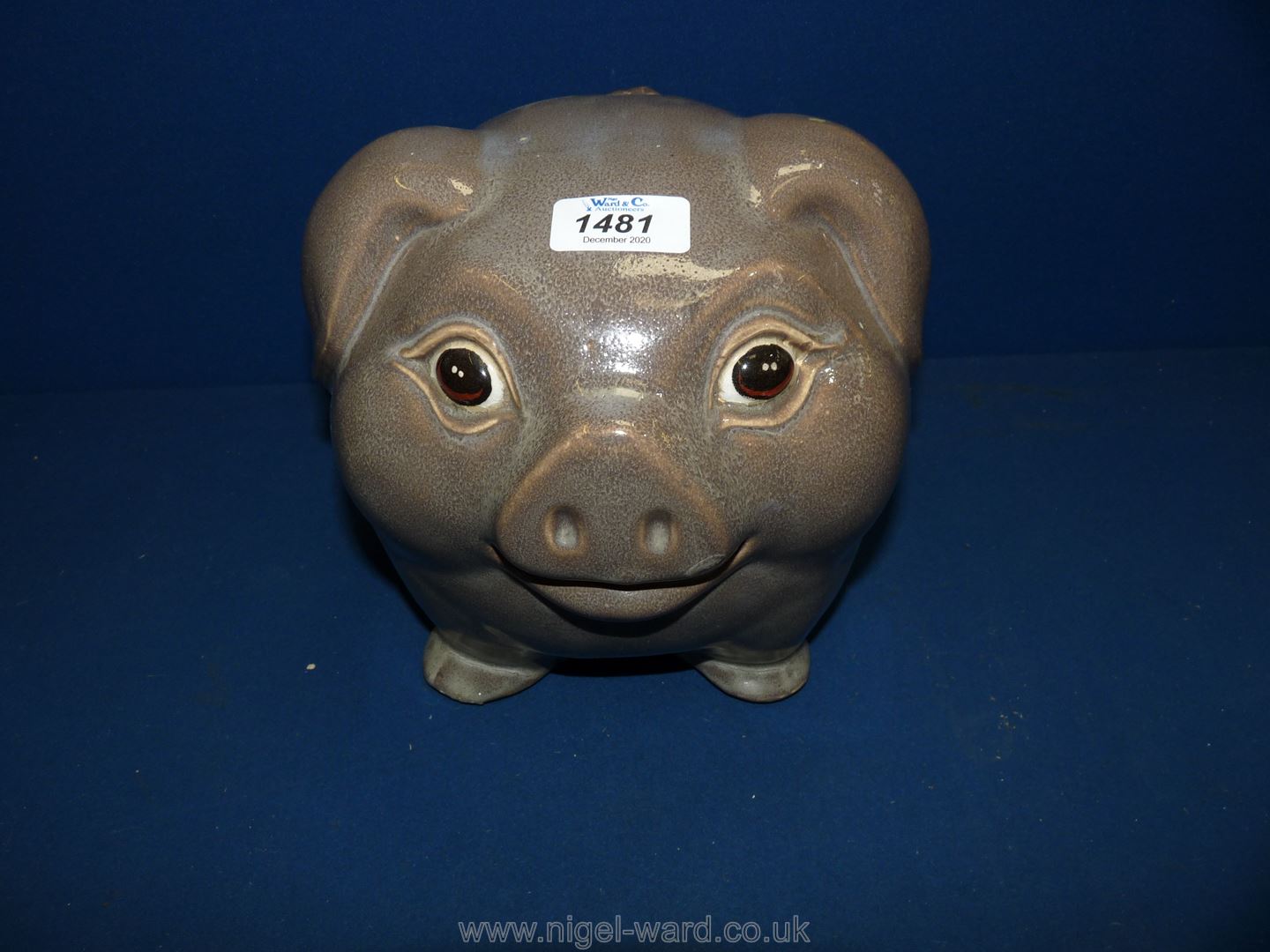 A large, grey, happy ceramic pig, 8" tall.