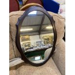 A shaped edge darkwood finished framed oval Wall hanging Mirror, 27" x 19" overall.