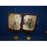 Two Victorian brass and fabric face Screens painted with flowers, with fringing and tassels,