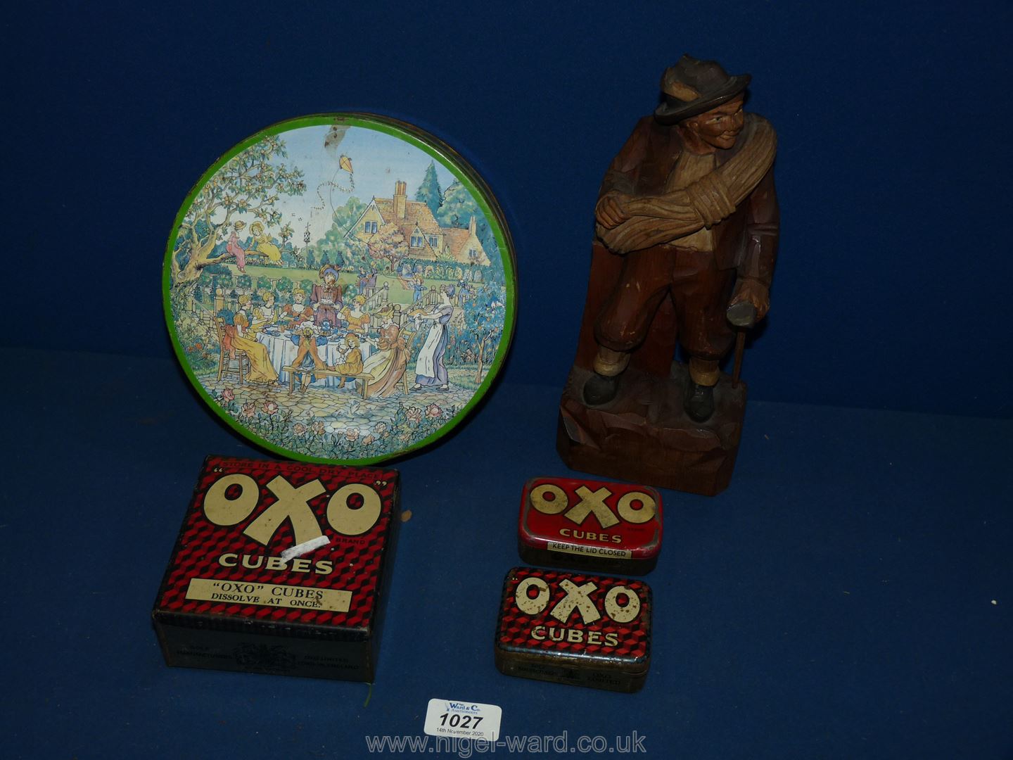 A Huntley & Palmer biscuit tin, three Oxo tins and a wooden figure of a man.