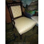 A circa 1900 ebonised framed, gold highlighted Nursing Chair having turned front legs,