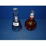 Two glass perfume bottles in blue and pink.