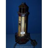 A Tiffany style lamp in the form of a lighthouse.