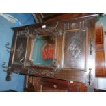 An Oak wall hanging Coat and Hat Rack with central eight sided bevelled mirror and bronzed hooks