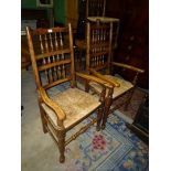 An antique pair of mixed woods Elbow Chairs having turned back rest supports and front legs/arm