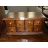 A wooden spice cupboard with eight drawers, 17 1/2" wide x 10" tall x 8 1/2" deep.