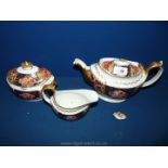 A trio of Crown Derby Tea ware comprising teapot, jug and sugar bowl with lid, in rust,