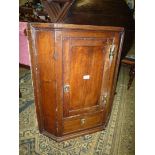 A compact circa 1800 Oak Corner Cupboard having brass 'H' hinges and unusually with a drawer below