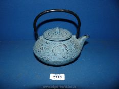 A heavy metal Japanese teapot with strainer, embossed with floral decoration,