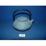 A heavy metal Japanese teapot with strainer, embossed with floral decoration,