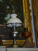 Two oil Lamps, one with white metal base, chimney and white shade,