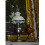 Two oil Lamps, one with white metal base, chimney and white shade,