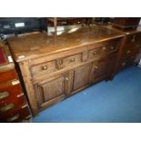 An Oak Jacobean type enclosed Dresser base having two twin-panelled frieze drawers with a