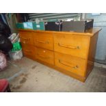 A honey coloured Oak Haberdashers Chest of six deep drawers fitted with long turned handles with