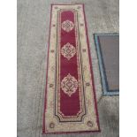 A long Runner with tan border and Burgundy panel to centre with three circular patterns,