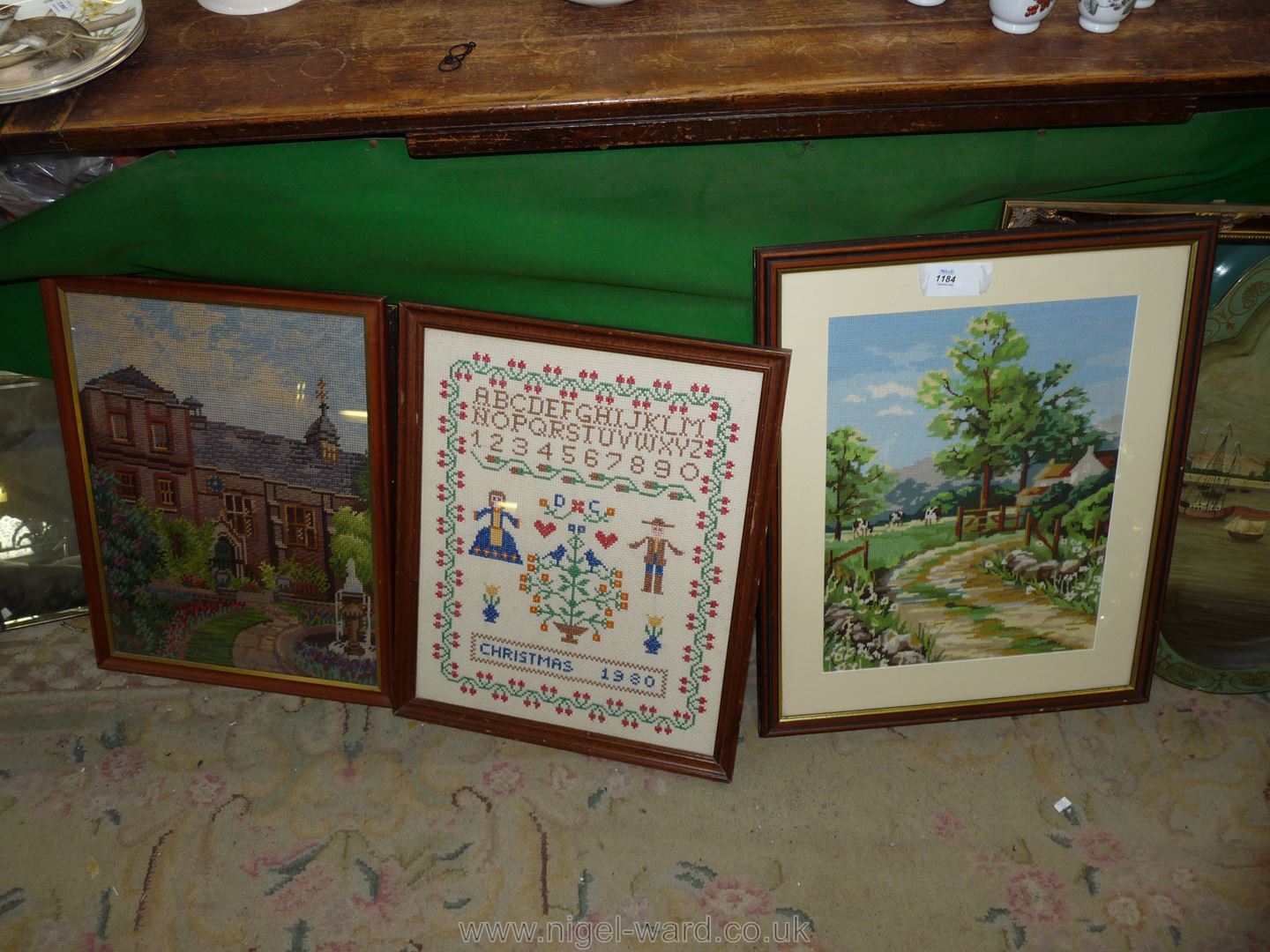 Three framed Tapestries depicting a country scene, Christmas 1980 and another.