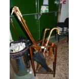 A triangular stick stand complete with five walking sticks (three with horn handles),