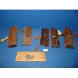 Six antique woodworking planes.