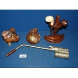 A wooden pipe stand with a pottery elephant piggy bank and pottery jug plus a metal opium pipe.