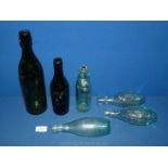 A small quantity of old pop bottles including one in dark glass.
