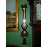 A wooden barometer, clock and thermometer combined with brass coloured faces, 33" long.