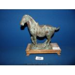A cast metal bronzed effect Tang Dynasty style horse on a wooden plinth, 9" tall.