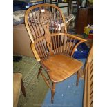 An appealing Elm seated Wheelback Elbow Chair, having turned legs united by an 'H' stretcher.