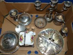 A box of silver plate including a three tier candelabra, two serviette rings,