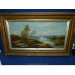 A gilt framed Oil on canvas depicting a river landscape with rolling hills in the distance and