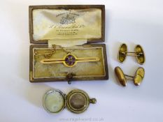 A presentation cased yellow metal bar Brooch set with four small amethysts and fitted with a safety