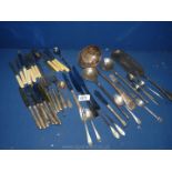 A quantity of plated and metal cutlery including dessert knives and forks, large ladle,