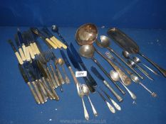 A quantity of plated and metal cutlery including dessert knives and forks, large ladle,