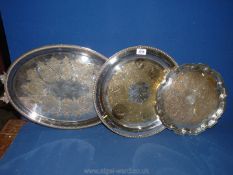 A white metal serving Tray, a silver plate Charger marked W.M.