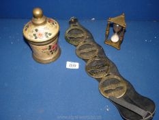 A quantity of brass including horse brasses, egg timer and brass pot with floral decoration.