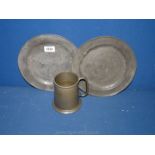 A 1950's pewter mug and two pewter plates, both 9 1/2'' diameter.