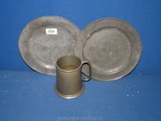 A 1950's pewter mug and two pewter plates, both 9 1/2'' diameter.