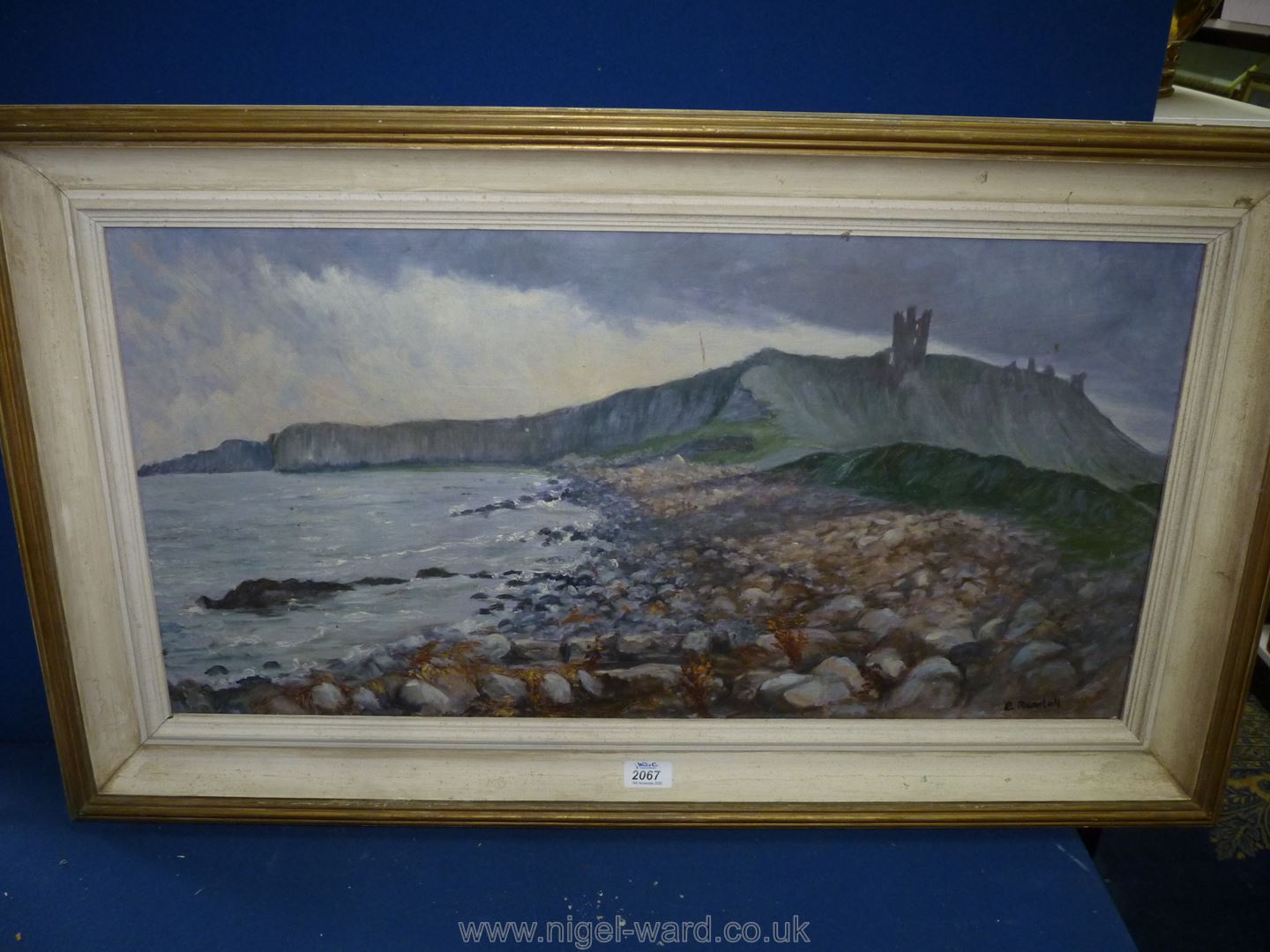 A large framed Oil on board depicting a coastal scene with large pebble beach,